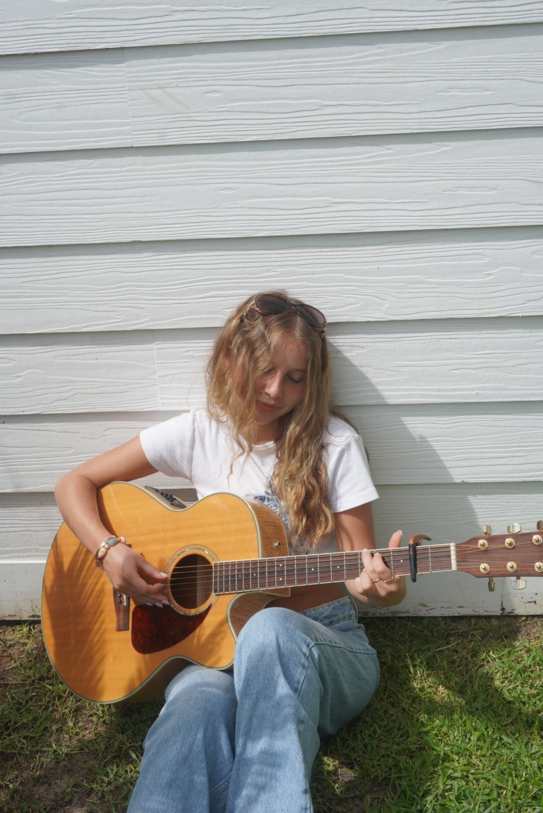 Playing an acoustic guitar on a balcony in the evening sun